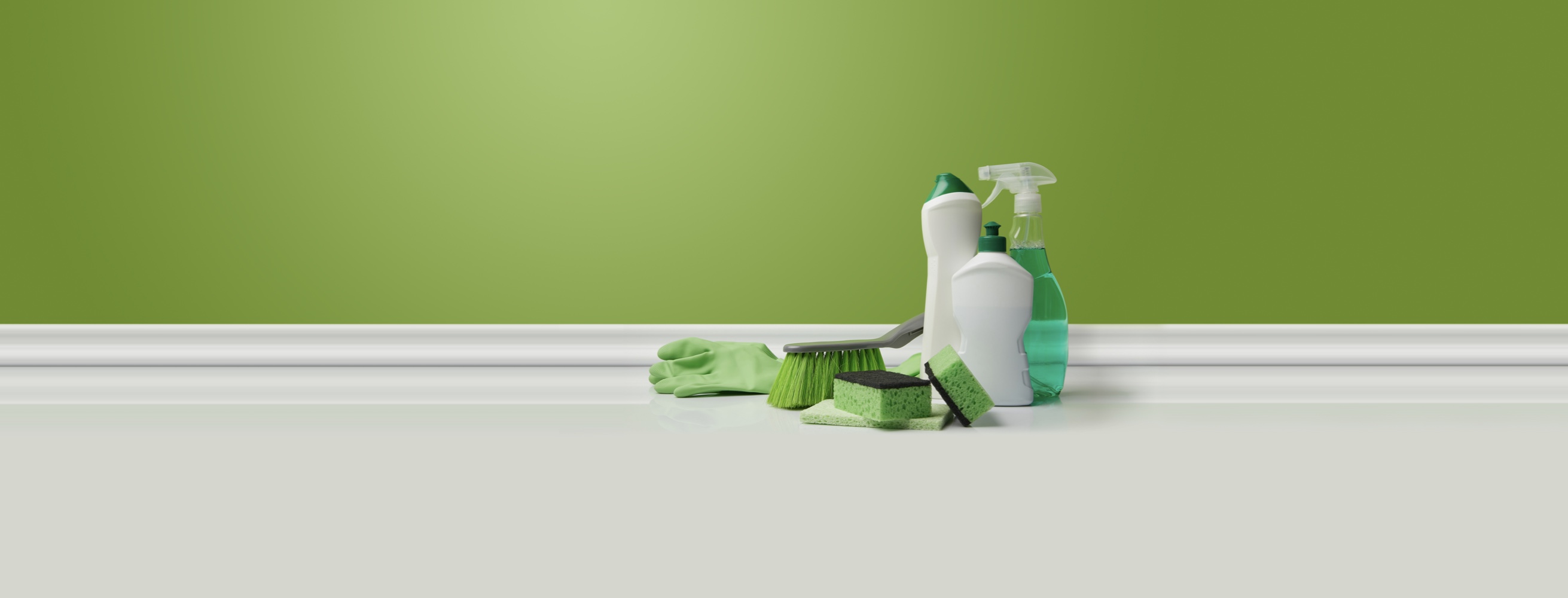 Green-colored cleaning supplies on a white floor next to a green wall.